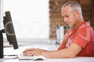 Businessman in office typing on computer