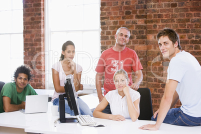 Five businesspeople in office space smiling