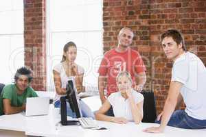 Five businesspeople in office space smiling