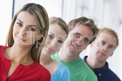 Four people standing in corridor smiling