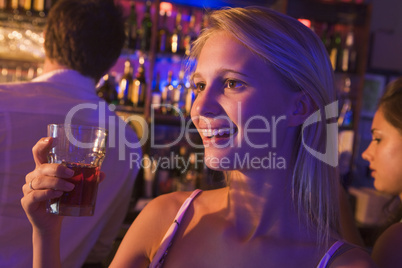 junge blonde Frau sitzt in einer Bar