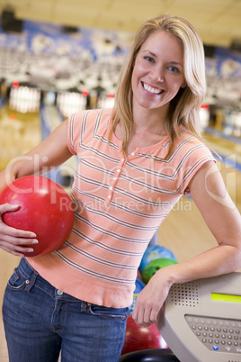 Eine junge Frau mit Bowlingkugel