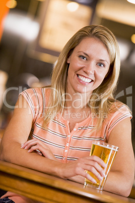 Eine blonde Frau mit einem Glas Bier