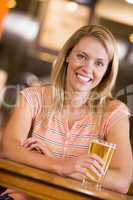 Eine blonde Frau mit einem Glas Bier