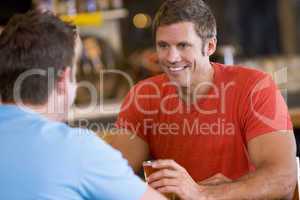 Ein Mann unterhält sich in einer Bar mit seinem Freund