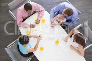 Four businesspeople in boardroom with one holding a baby