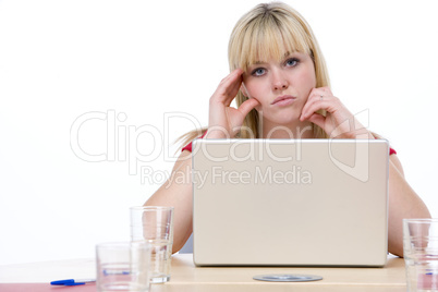 Businesswoman sitting in boardroom with laptop looking unhappy