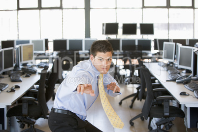 Businessman standing in karate stance in computer room