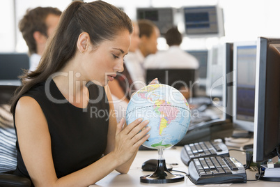 Businesswoman in office space with desk globe