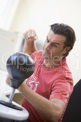 Businessman in office using small punching bag to relieve stress