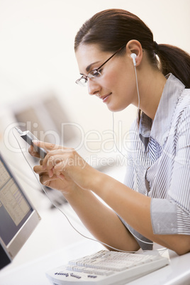 Woman in computer room listening to MP3 Player