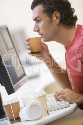 Man in computer room with many empty cups of coffee