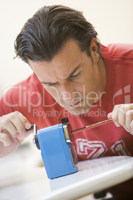 Man indoors using pencil sharpener