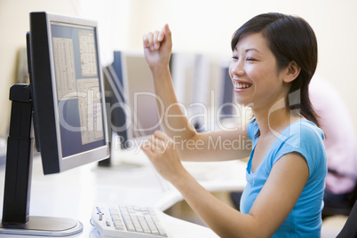 Woman in computer room cheering and smiling