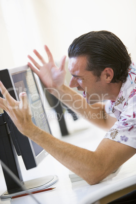 Man in computer room frustrated at monitor