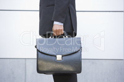 Businessman holding briefcase outdoors