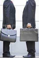 Two businessmen holding briefcases outdoors