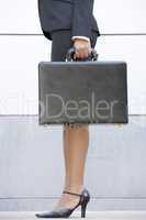Businesswoman holding briefcase outdoors
