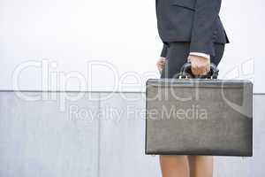 Businesswoman holding briefcase outdoors