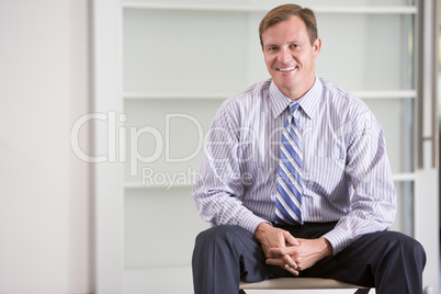 Businessman sitting indoors smiling