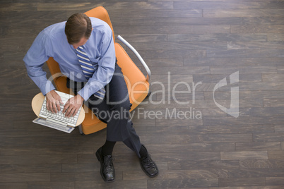 Businessman sitting indoors with laptop