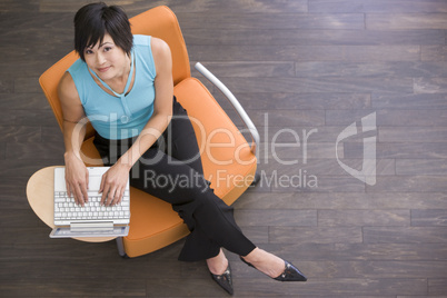 Businesswoman sitting indoors with laptop