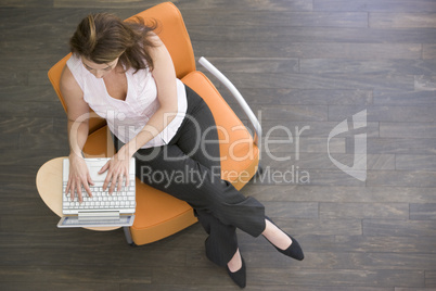 Businesswoman sitting indoors with laptop