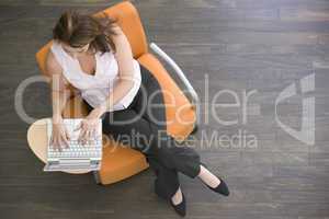 Businesswoman sitting indoors with laptop