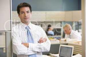 Businessman standing in cubicle