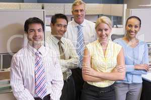 Business team standing in cubicle smiling
