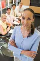 Businesswoman with four businesspeople at boardroom table in bac