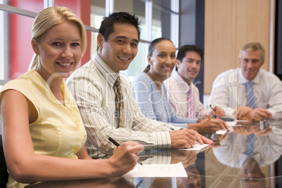 Five businesspeople in boardroom smiling