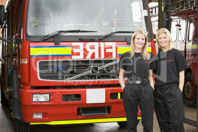 Zwei Feuerwehrfrauen vor einem Löschfahrzeug