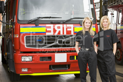 Zwei Feuerwehrfrauen vor einem Löschfahrzeug