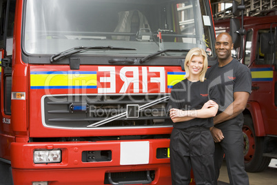 Eine Feuerwehrfrau und ein Feuerwehrmann vor einem Löschfahrzeug