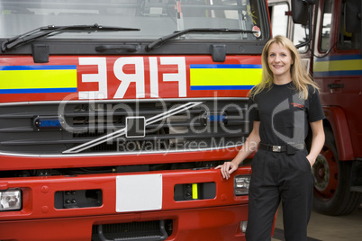 Eine Feuerwehrfrau steht vor einem Löschfahrzeug