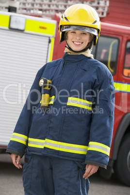 Eine Feuerwehrfrau steht vor einem Löschfahrzeug