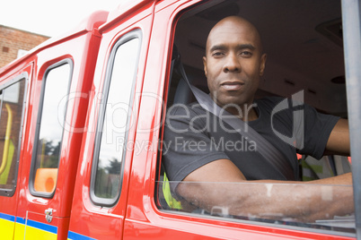 Ein Feuerwehrmann sieht aus dem offenen Fenster eines Feuerwehrfahrzeuges heraus