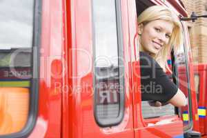Eine Feuerwehrfrau sieht aus dem offenen Fenster eines Feuerwehrfahrzeuges heraus