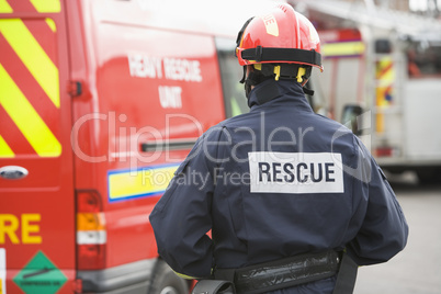 Eine Feuerwehrmann steht vor einem Feuerwehrfahrzeug