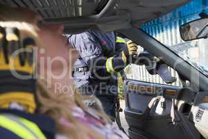Ein Feuerwehrmann befreit eine verunglückte Autofahrerin mit einer Rettungsschere