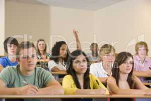 College student with hand raised in university lecture hall