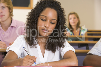 Female college student taking notes in a university lecture