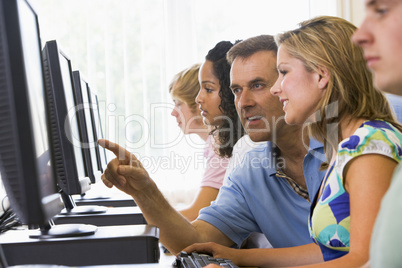 Teacher assisting college student in a computer lab