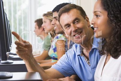 Teacher assisting college student in a computer lab