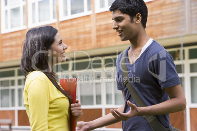 Male and female college students talking on campus