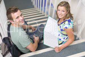 Male and female college students sitting on stairs