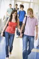 Young couple walking down university corridor