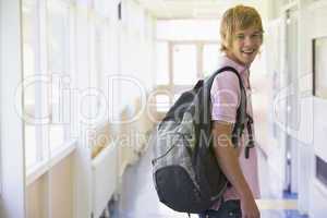 Male college student standing in university corridor