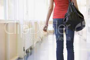 Rear view of female college student in university corridor